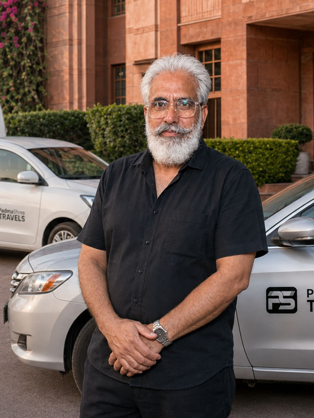A member of the Padma Shree Travels team standing between two branded company cars